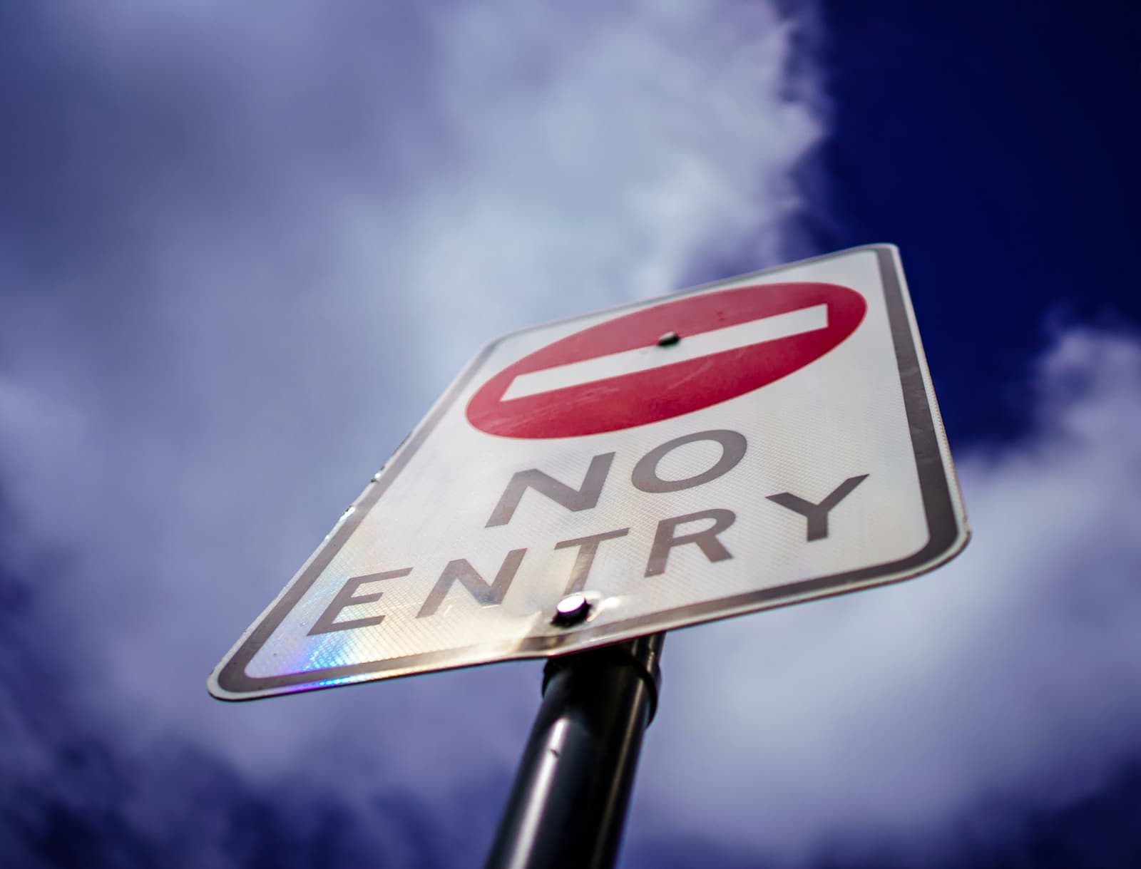 A “No entry” road sign against a cloudy sky