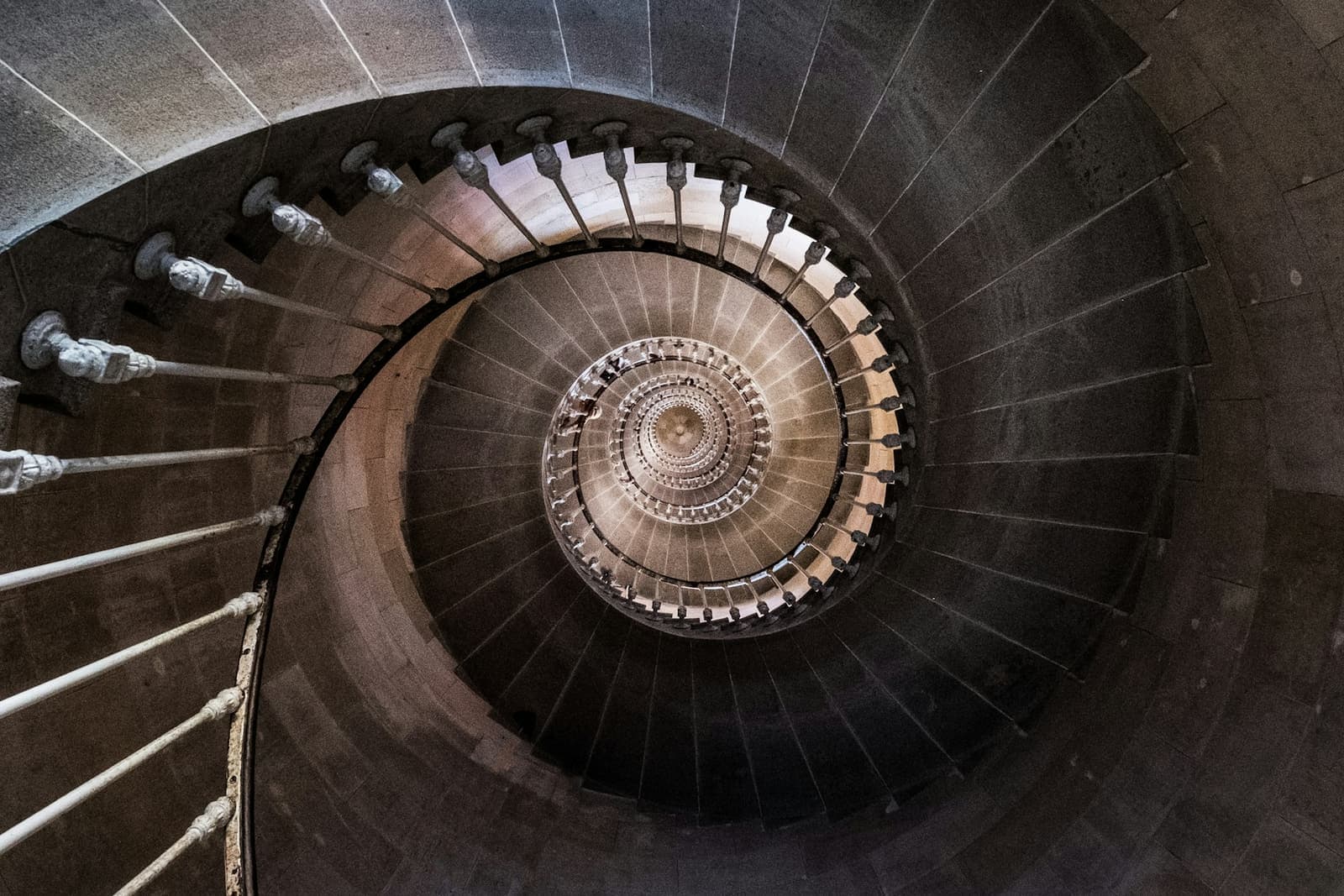 A stone spiral staircase seen from above, its turns winding into the centre