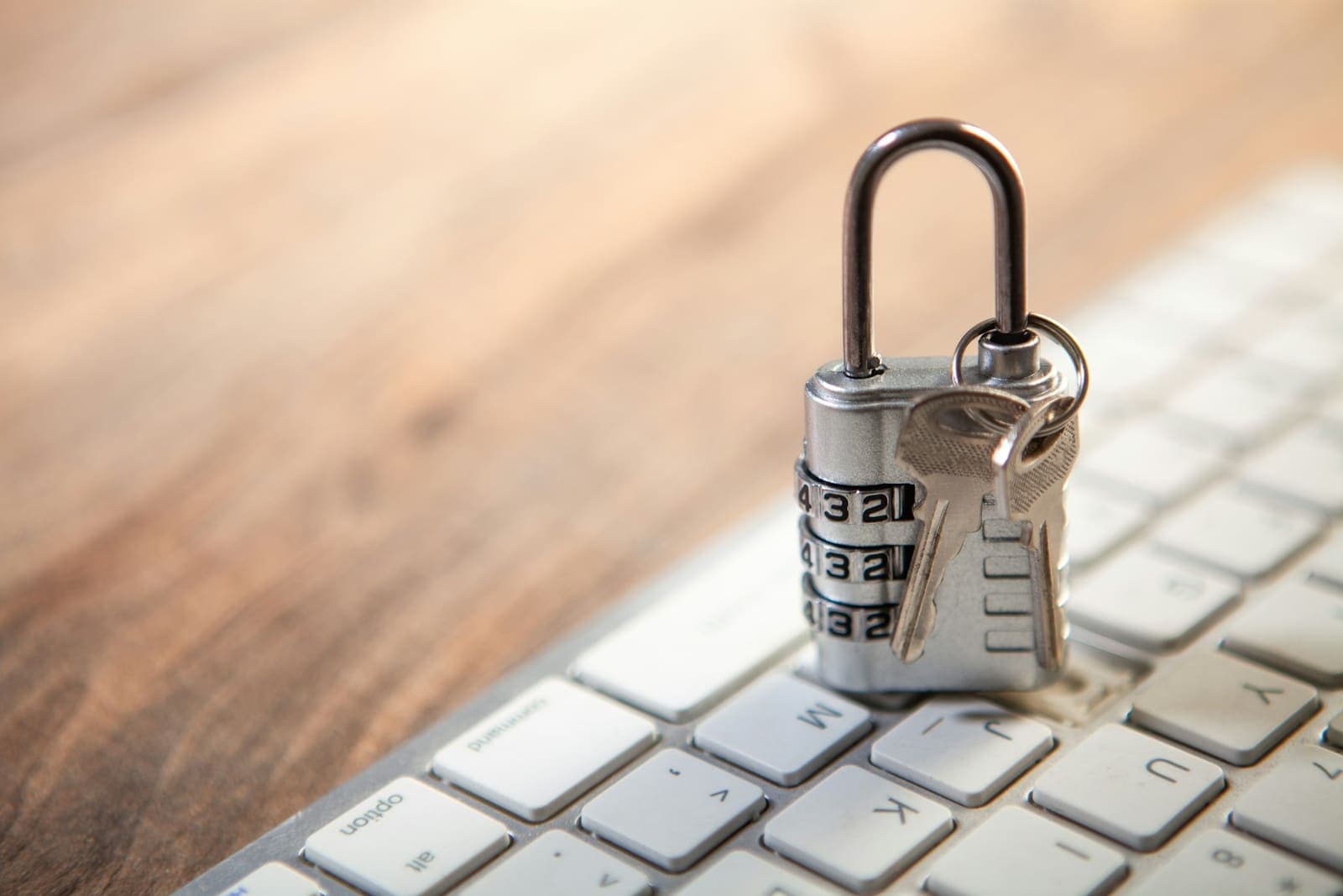 A combination padlock with keys on a computer keyboard