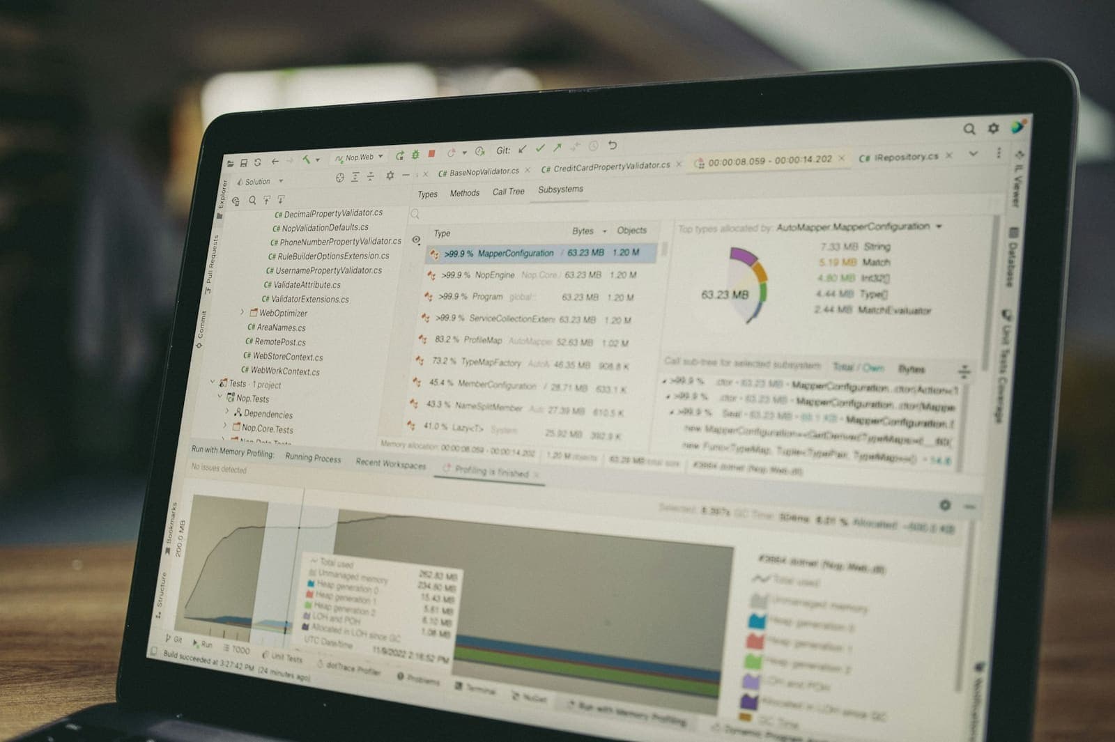A laptop showing a profiler with a list of types, memory use and a graph