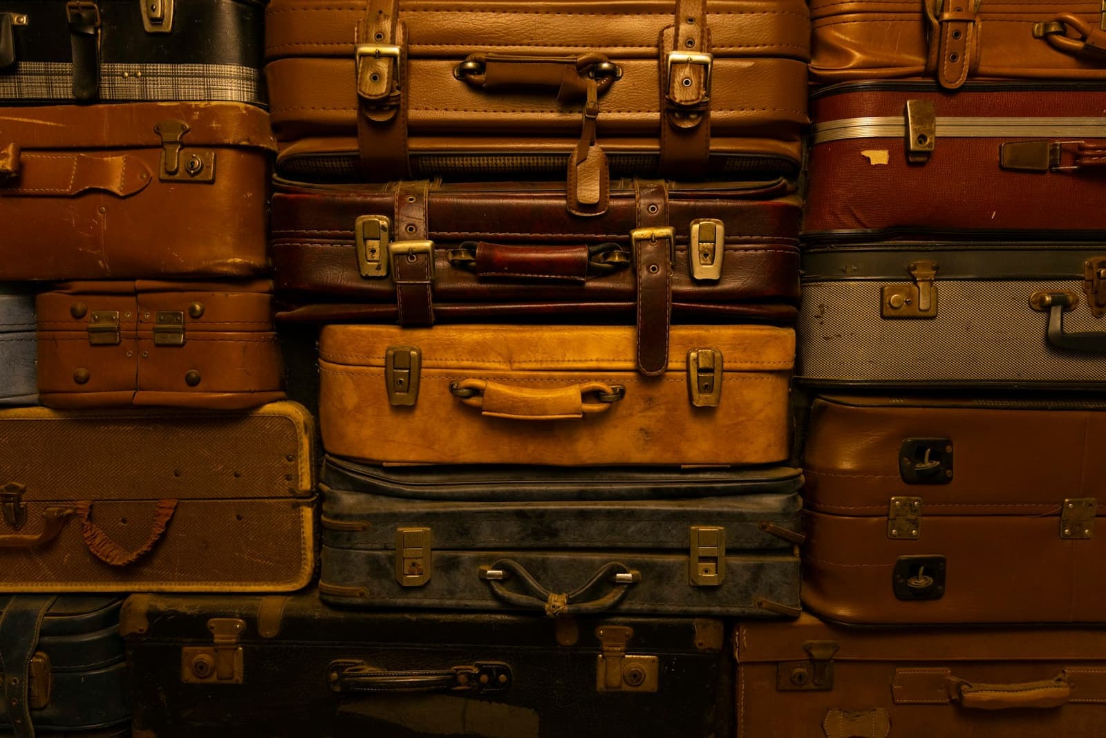 A wall of old leather suitcases stacked on top of one another