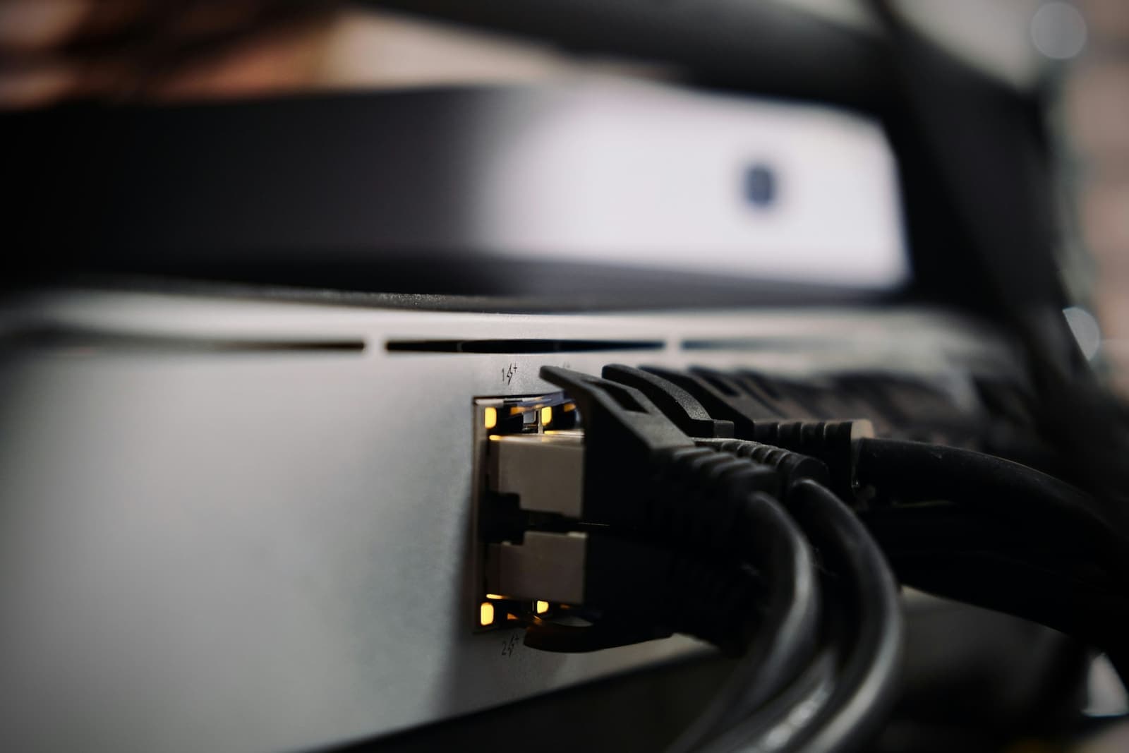 Black Ethernet cables plugged into the ports of a network device